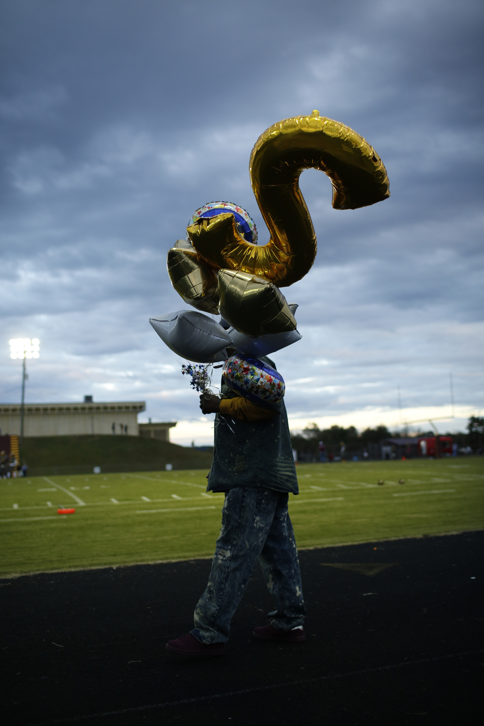 James Pickett Jr. carries senior night balloons for his son James Pickett III, who is in the band, before Tyner's prep football game at Tyner High School on Friday, Oct. 27, 2017, in Chattanooga, Tenn.