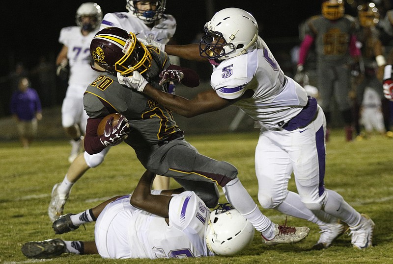 Tynerճ Jeremy Elston (20) is tackled by Centralճ Vincent McColley (5) and Chance Martin (51) during their prep football game at Tyner High School on Friday, Oct. 27, 2017, in Chattanooga, Tenn.