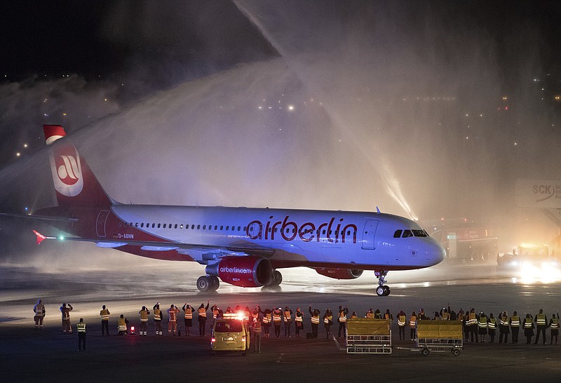 
              In this Oct. 27, 2017 photo the last plane of German airline Air Berlin is welcomed by the airport fire brigade with a water fountain at Tegel airport in Berlin, Germany. It was the last flight of Air Berlin after the airline declared bankruptcy in August 2017. (Soeren Stache/dpa via AP)
            