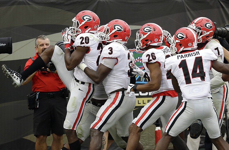 Georgia defensive back J.R. Reed (20) celebrates with teammates, including linebacker Roquan Smith (3), defensive back Tyrique McGhee (26) and defensive back Malkom Parrish (14), after Reed recovered a Florida fumble and returned it for a touchdown during the Bulldogs' 42-7 win Saturday in Jacksonville, Fla.