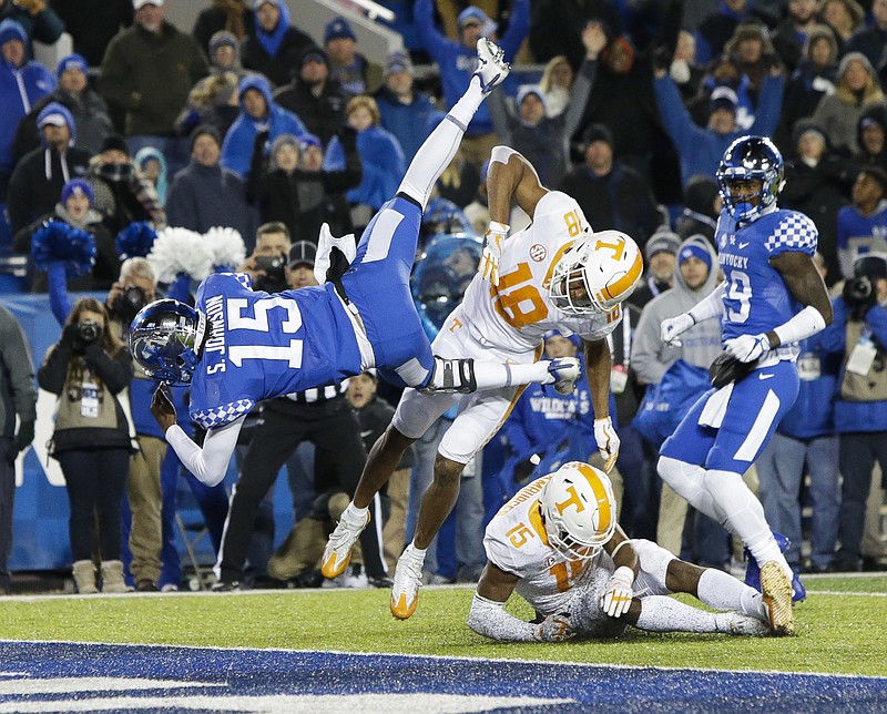 Kentucky quarterback Stephen Johnson dives into the end zone for a game-winning touchdown over Tennessee defensive back Nigel Warrior (18) and defensive back Shawn Shamburger (15) during the second half of an NCAA college football game Saturday, Oct. 28, 2017, in Lexington, Ky. Kentucky won the game 29-26. (AP Photo/David Stephenson)