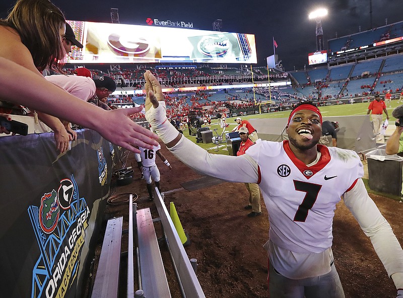 Georgia senior outside linebacker Lorenzo Carter celebrates with fans after Saturday's 42-7 win over Florida at EverBank Field in Jacksonville.