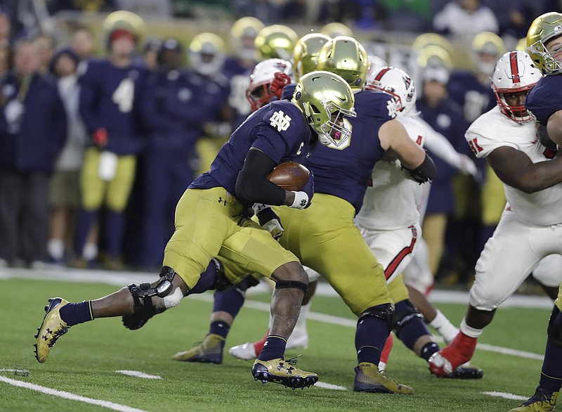 Notre Dame's Josh Adams bursts through the line for a 77-yard touchdown run during Saturday's 35-14 victory against N.C. State in South Bend, Ind.