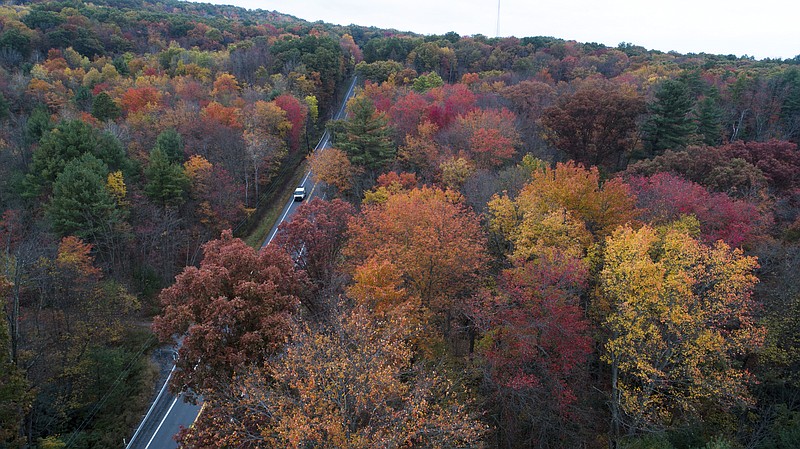 FILE - This Monday, Oct. 23, 2017 file photo show fall colors beginning to show along Route 209 in Reilly Township, Schuylkill County, Pa. Across the United States, 2017’s first freeze has been arriving further and further into the calendar, according to more than a century of measurements from weather stations nationwide. (David McKeown/Republican-Herald via AP)