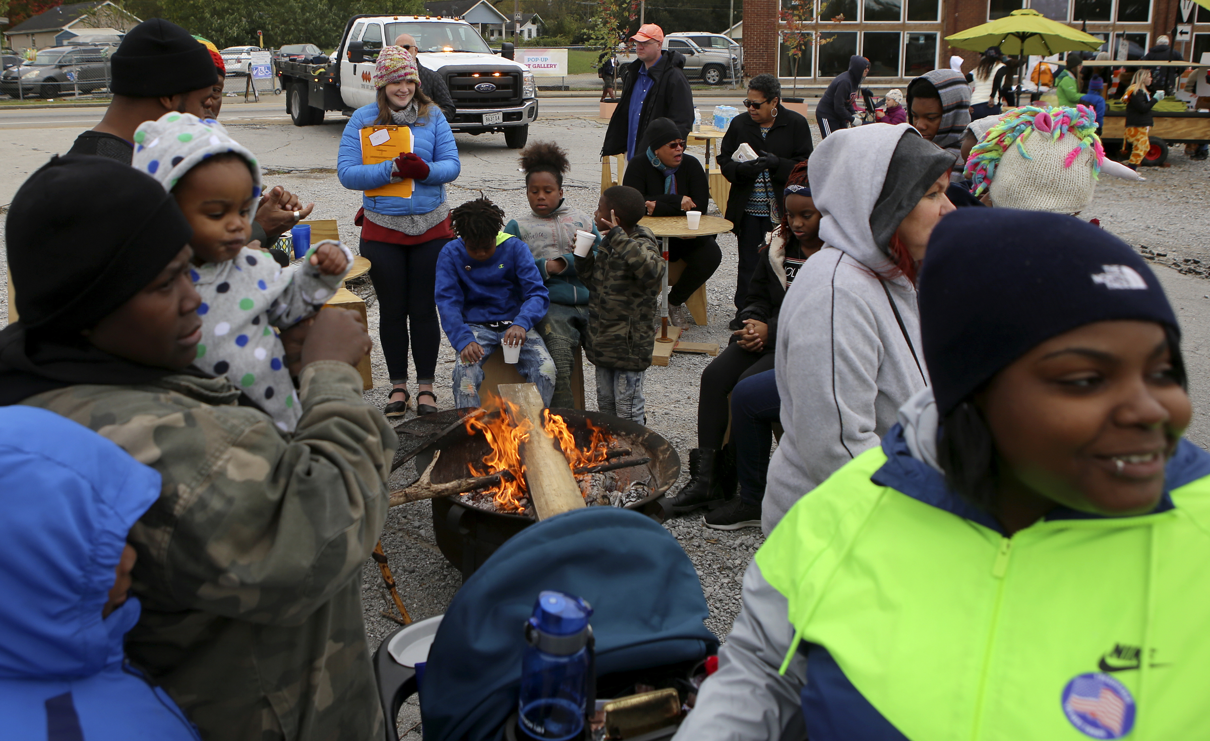 People gather around the fire during the Glass Street Live! stop of the City Celebration and Ciclovia on Sunday, Oct. 29, 2017 in Chattanooga, Tenn. The Celebration and Civlovia was a 4-mile rolling block party with stops in five East Chattanooga neighborhoods.
