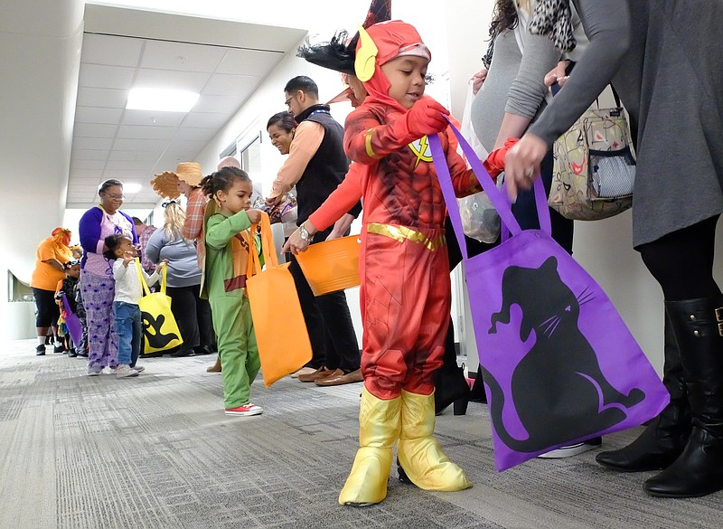 Brian, dressed as The Flash, and Ja'Erick Fluellen, a Teenage Mutant Ninja Turtle, hold their bags open wide to receive candy Tuesday morning at Lookout Place in the TVA complex. More than 100 TVA employees lined the atrium inside the Chattanooga headquarters to welcome trick-or-treaters from the Chambliss Center for Children.