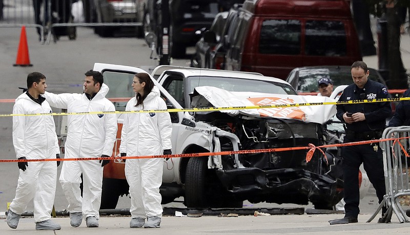 Law enforcement personnel examine the scene Wednesday, Nov. 1, 2017, after a driver mowed down people on a riverfront bike path near the World Trade Center on Tuesday in New York. (AP Photo/Mark Lennihan)