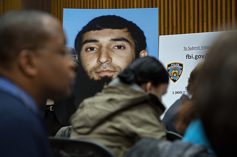 A photo of Sayfullo Saipov is displayed at a news conference at One Police Plaza Wednesday, Nov. 1, 2017, in New York. Saipov is accused of driving a truck on a bike path that killed several and injured others Tuesday near One World Trade Center. (AP Photo/Craig Ruttle)