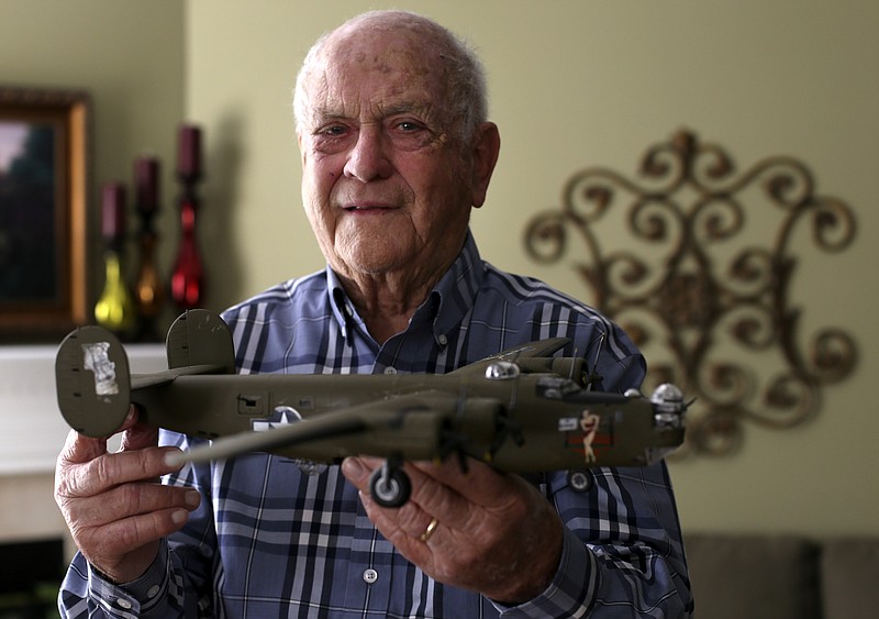 Veteran Don Womack poses with a model of a B-24 at his home on Thursday, Oct. 26, 2017 in Chattanooga, Tenn. Womack served in the Army Air Force during World War II as the lower ball turret gunner aboard a B-24.