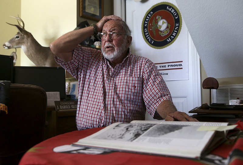 James Harold Silcox mimics himself taking cover from North Vietnamese Army fire, from a photo in the book "America Takes Over" from The Vietnam Experience collection, on Wednesday, Oct. 25, 2017 in Fort Oglethorpe, Ga. Silcox served two tours of duty in Vietnam as a Marine.

