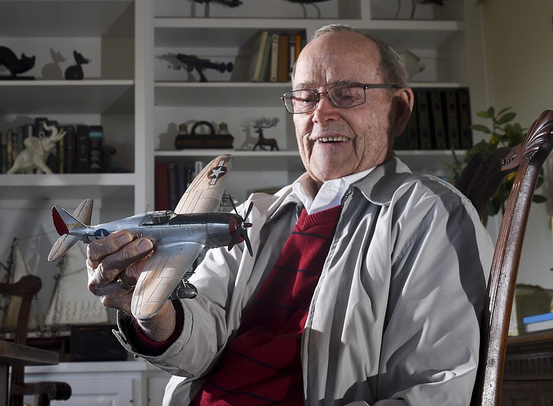 William Hartshorn, 94, holds a model Thunderbolt P-47 airplane like he flew in 1944.