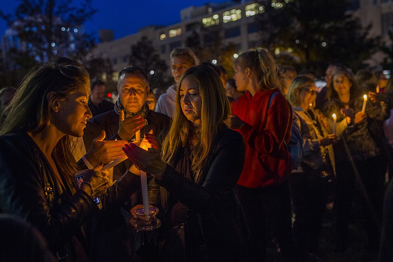 People light candles as they gather to remember the victims of the recent truck attack during a candle light walk along the Hudson River near the crime scene on Thursday, Nov. 2, 2017, in New York. A man in a rental truck mowed down pedestrians and cyclists along the busy bike path near the World Trade Center memorial on Tuesday, killing at least eight people and seriously injuring others in what the mayor called "a particularly cowardly act of terror." (AP Photo/Andres Kudacki)