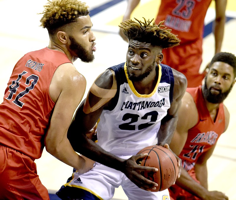 UTC's Makinde London (22) looks for a shot between two Patriots.  The Francis Marion University Patriots visited the University of Tennessee at Chattanooga Mocs in a exhibition game at McKenzie Arena on Nov. 4, 2017