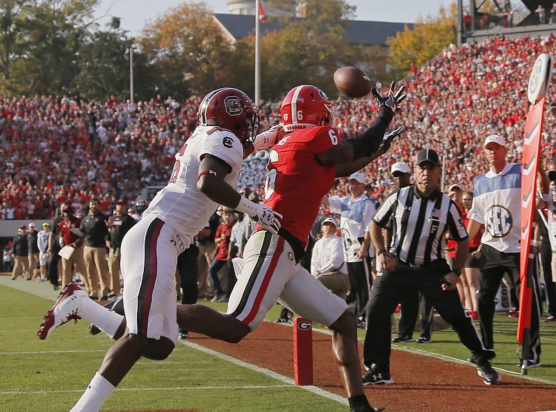 Georgia wide receiver Javon Wims (6) scores, on a pass that was originally ruled incomplete, next to South Carolina defensive back Rashad Fenton (16) during an NCAA college football game Saturday, Nov. 4, 2017, in Athens, Ga. (Bob Andres/Atlanta Journal Constitution via AP)