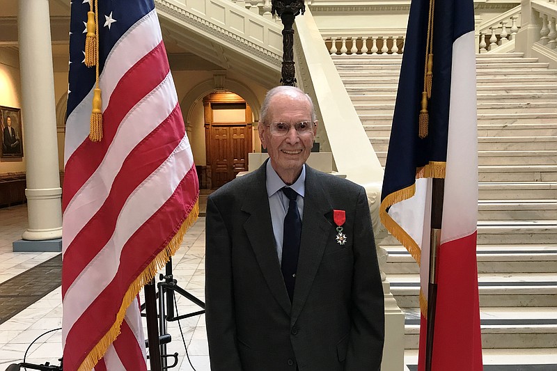 East Ridge resident Donald Seesenguth stands between the American and French flags, symbolic of his military service which earned him a Purple Heart and, recently, the French Legion of Honor.