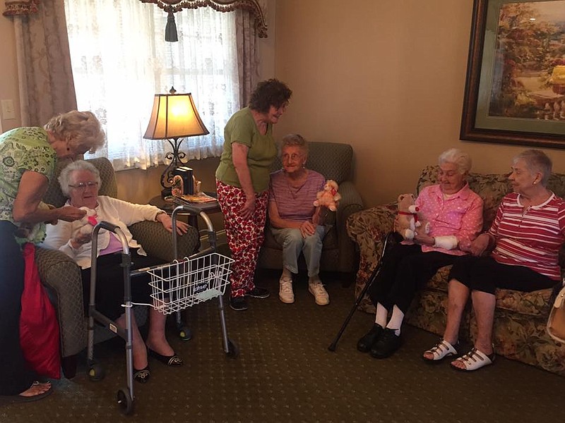 Sandra Radant, aka "the Toy Lady," and other volunteers from the Ladies of Charity Thrift Store present a toy to each of the seniors at Southern Heritage Assisted Living. (Contributed photo)