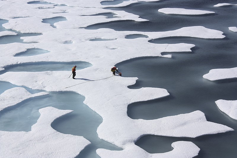 FILE — Crewmembers with the U.S. Coast Guard Cutter Healy retrieve supplies during their ICESCAPE Mission in the Arctic Ocean in 2011. As more carbon is pumped into the atmosphere, scientists warn that the Arctic will become ice-free in a matter of decades. (NASA via The New York Times)