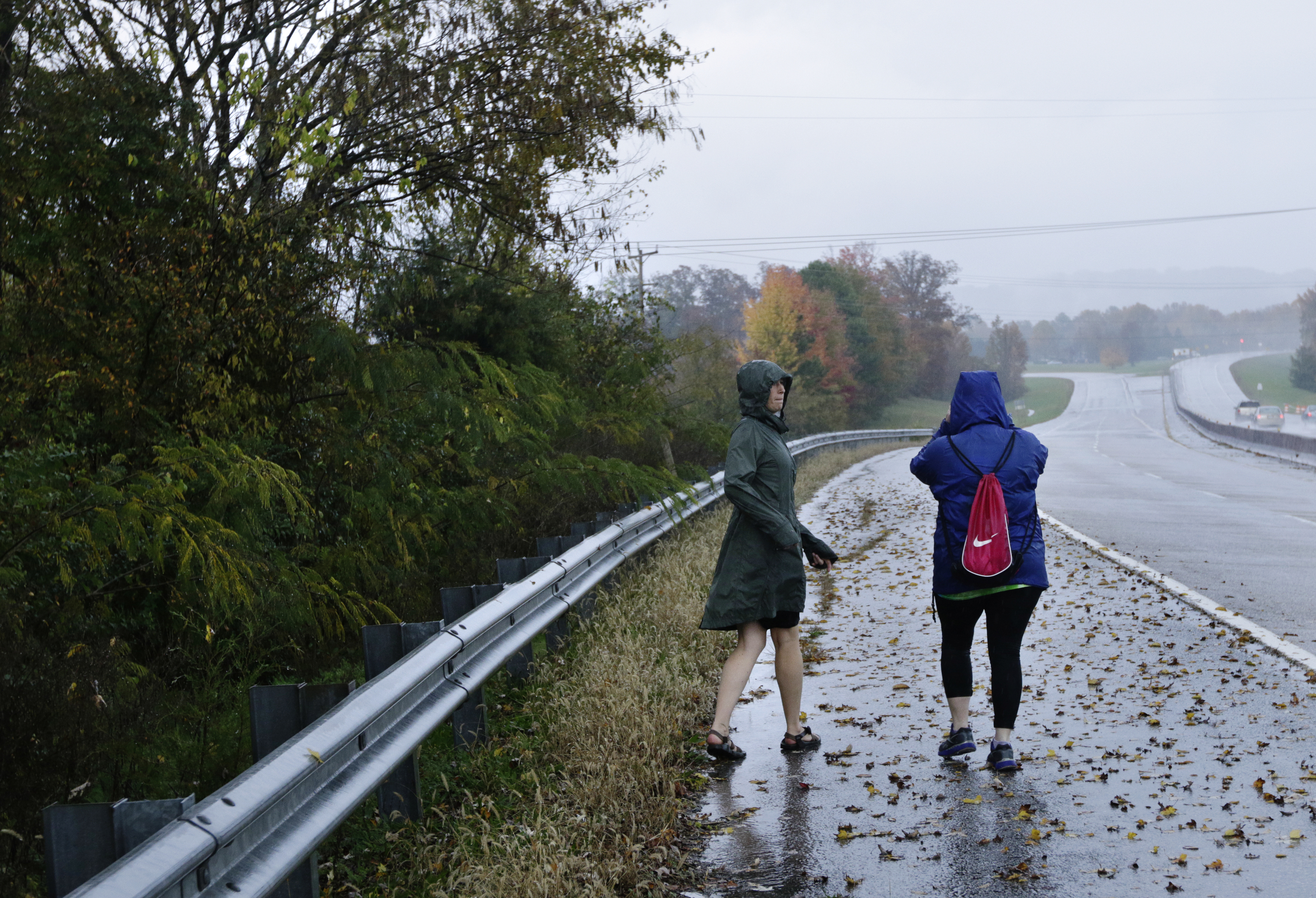 Sara McIntyre, left, and a volunteer who declined to give their name search for signs of missing CSAS 2nd grade teacher John Eaton along DuPont Parkway on Tuesday, Nov. 7, 2017, in Chattanooga, Tenn. Eaton left home on Sunday for the school but never returned. Volunteers searched Eaton's typical route from Sequoyah Access Road along U.S. Highway 27, Tennessee Highway 153, DuPont Parkway, and Amnicola Highway to the school.