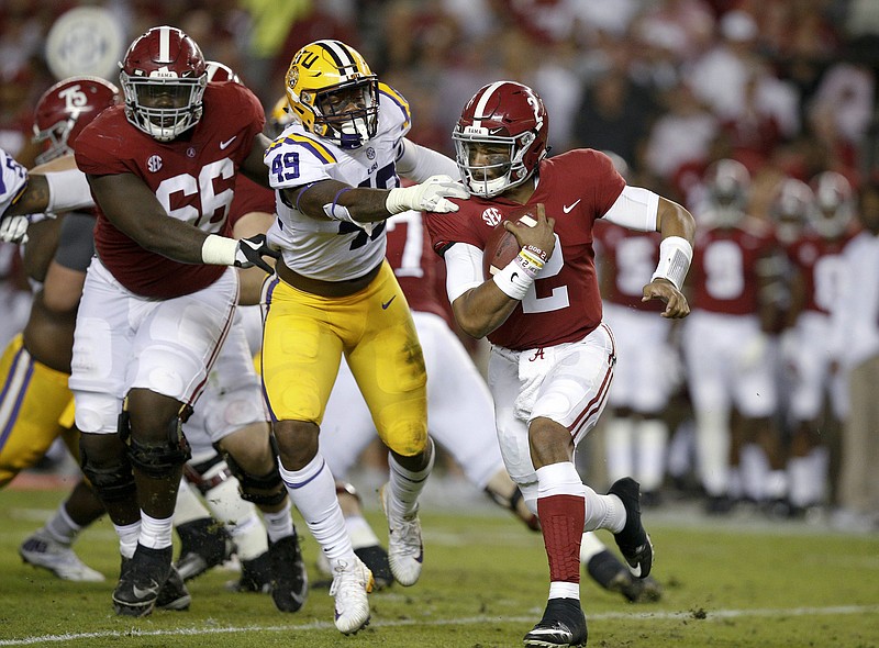 Alabama quarterback Jalen Hurts carries the ball before being tackled by LSU linebacker Arden Key during the first half of an NCAA college football game, Saturday, Nov. 4, 2017, in Tuscaloosa, Ala. (AP Photo/Brynn Anderson)