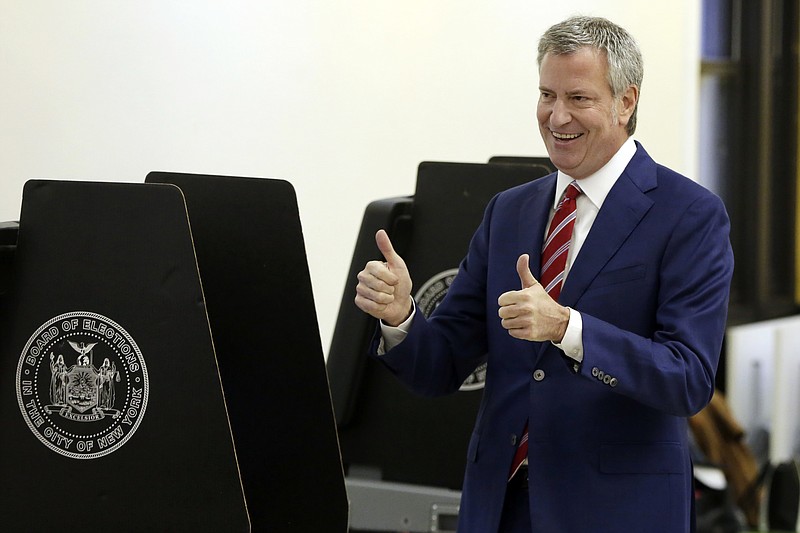 New York Mayor Bill de Blasio signals a double thumbs-up after voting at the Park Slope Library, in the Brooklyn borough of New York, Tuesday, Nov. 7, 2017. De Blasio is seeking his second term leading the nation's largest city. (AP Photo/Richard Drew)