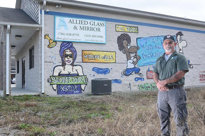 Walter Dix, owner of Allied Glass and Mirror in Rossville, stands in front of a mural that was painted on the side of his building facing Mack Smith Road.