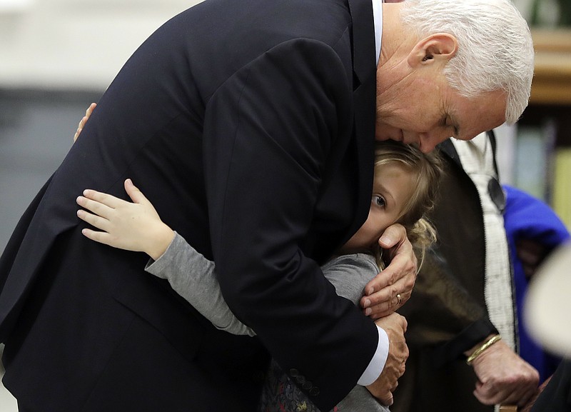 Vice President Mike Pence hugs Evelyn Holcombe at Florseville High School during a stop, Wednesday, Nov. 8, 2017, in Floresville, Texas. A man opened fire inside a church in Sutherland Springs on Sunday, killing and wounding many; Holcombe was in the church during the shooting but escaped. (AP Photo/Eric Gay)