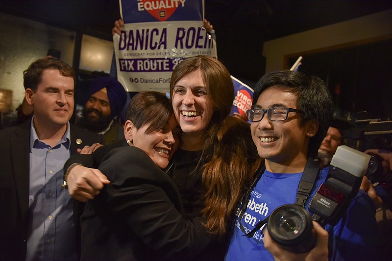 In this Nov. 7, 2017, file photo, Danica Roem, center, who ran for house of delegates against GOP incumbent Robert Marshall, is greeted by supporters as she prepares to give her victory speech with Prince William County Democratic Committee at Water's End Brewery in Manassas, Va. Transgender woman Roem, whose defeat of an outspoken, socially conservative lawmaker has made news around the world, is just one of several women who made history in this week's Virginia elections. The state House is also getting its first Latina members, its first Asian-American woman delegate and likely its first openly lesbian member. (Jahi Chikwendiu/The Washington Post via AP, File)