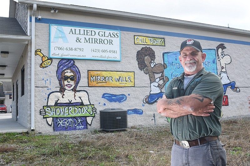 Walter Dix, owner of Allied Glass and Mirror in Fort Oglethorpe, stands in front of a mural that was painted on the side of his building facing Mack Smith Road.