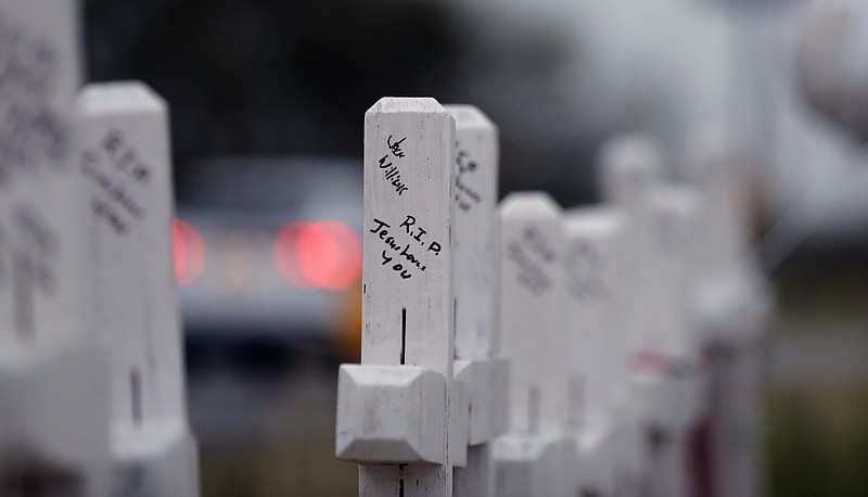 Hand-written messages on crosses are part of a makeshift memorial for the victims of the church shooting at Sutherland Springs Baptist Church placed along the highway , Friday, Nov. 10, 2017, in Sutherland Springs, Texas. A man opened fire inside the church in the small South Texas community on Sunday, killing more than two dozen. (AP Photo/Eric Gay)