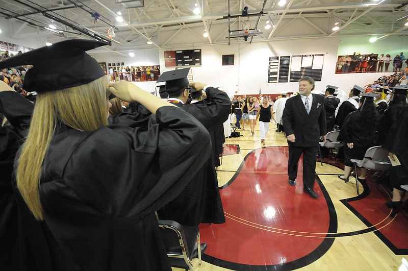 In this May 15, 2014, staff file photo, graduating senior Shelbi Mullinax, near left, salutes as Maj. Jeff McDonald, technology teacher at Southeast Whitfield High School, is honored by local Marines, school staff and students in Dalton.