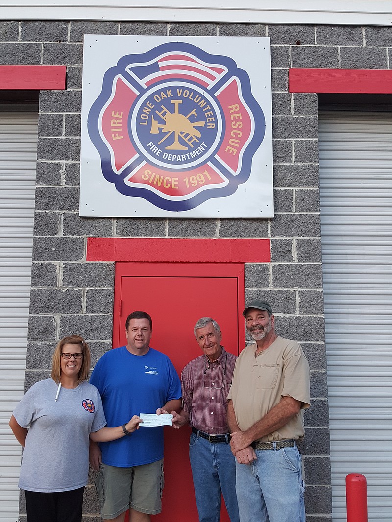 Lone Oak Volunteer Fire Department Chief Dana Clift and Tommy Johnson, president and chairman of the Lone Oak board, accept a $1,200 donation from Joe Galbraith and Mark Jonakin of the Men of St. Timothy's ministry collected through its 2016 tree sale. (Contributed photo)