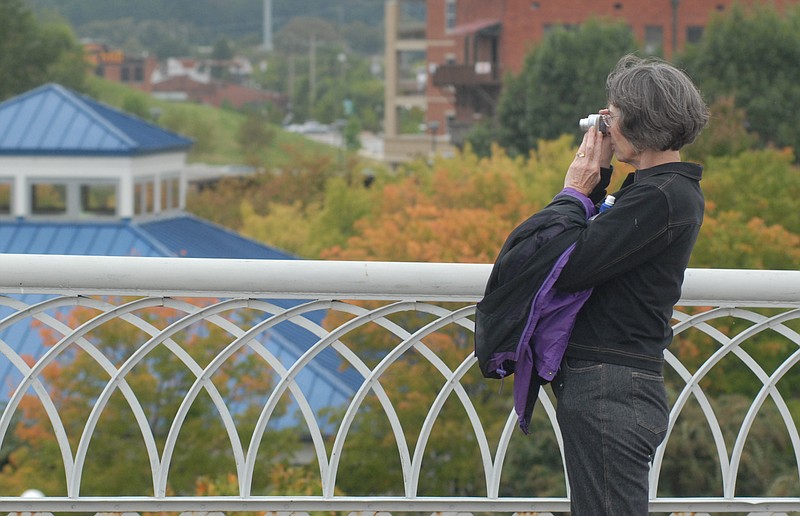 With the maple trees in Coolidge Park beginning to change to autumn colors, Judi Case, visiting Chattanooga from Murfreesboro, Tenn., takes a photograph from the Walnut Street Bridge.
