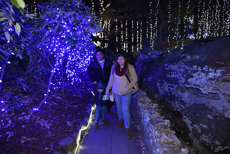 Diego, left, Nancy, right, and Dylan Avila, from Dalton, Ga., pass through Blizzard's Pass and Penguin Point at Rock City's Enchanted Garden of Lights Sunday, Nov. 20, 2016. The lighted attraction will be open every evening from 6-9 p.m. through New Years Eve, and closed on Christmas Eve.