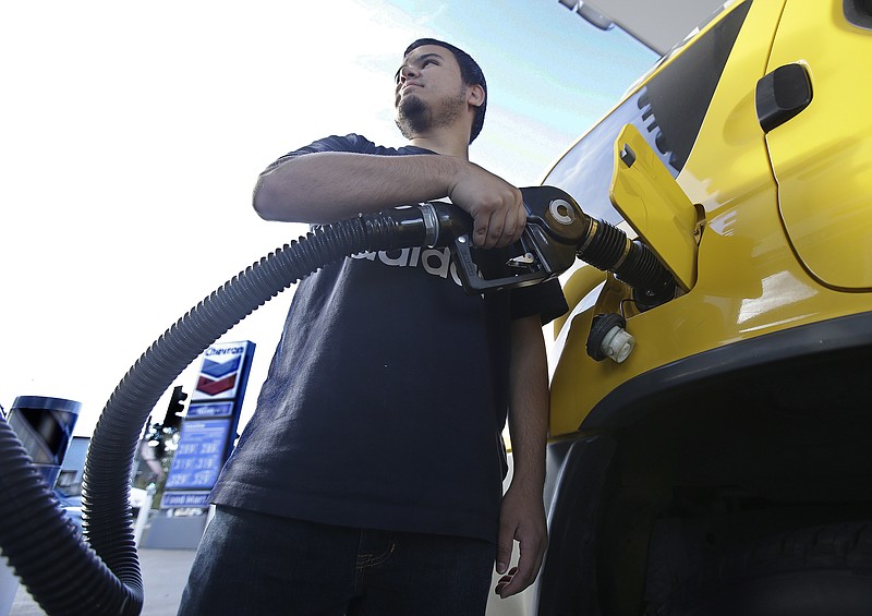 FILE - In this Monday, Oct. 30, 2017, file photo, Cristian Rodriguez fuels his vehicle in Sacramento, Calif. The price of oil has risen by about one-third since the summer, but many experts think the surge won’t last. They point to growing U.S. production. Still, higher prices for energy could translate into higher prices for airline tickets and consumer goods. (AP Photo/Rich Pedroncelli, File)