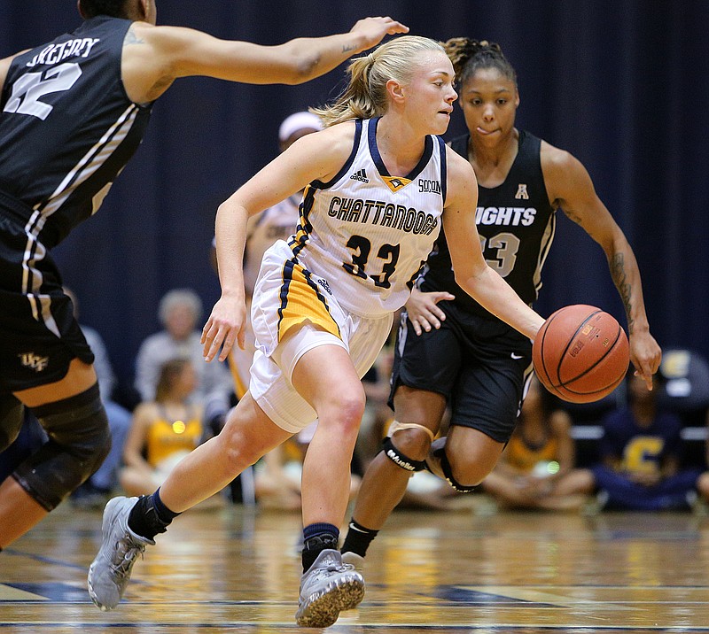 University of Tennessee at Chattanooga guard Lakelyn Bouldin (33) dribbles the ball downcourt while being guarded by University of Central Florida's Aliyah Gregory (22) and Lawriell Wilson (23) during the UTC girls basketball game against UCF at Maclellan Gym Monday, Nov. 13, 2017, in Chattanooga, Tenn. The Mocs fell to the Knights 57-58 in their home opener. 