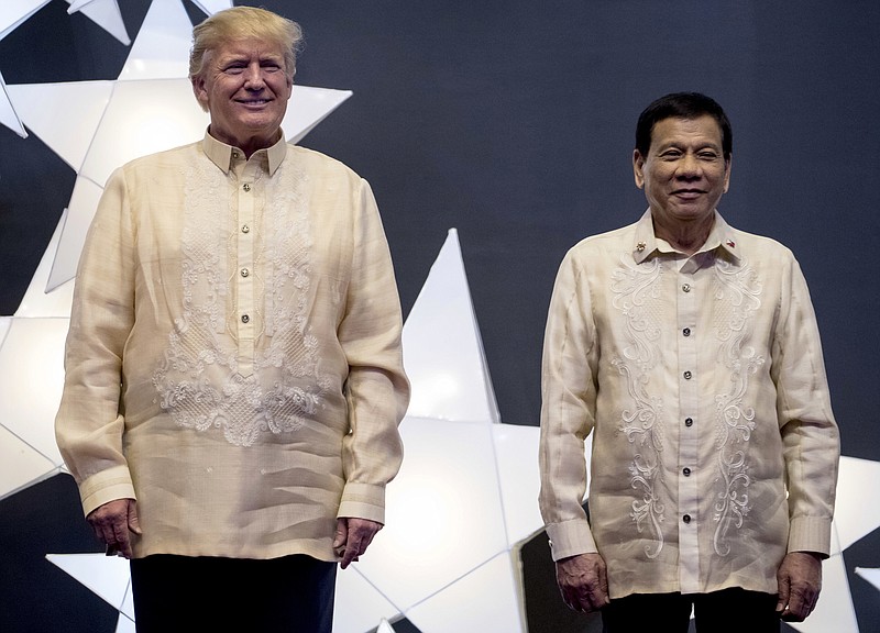 President Donald Trump and Philippines President Rodrigo Duterte, right, join other leaders for a family photo at an ASEAN Summit dinner at the SMX Convention Center, Sunday, Nov. 12, 2017, in Manila, Philippines. (AP Photo/Andrew Harnik)
