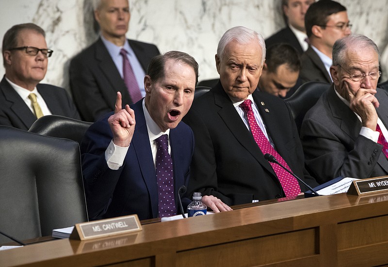 Sen. Ron Wyden, D-Ore., left, the top Democrat on the Senate Finance Committee, criticizes the Republican tax reform plan while Chairman Orrin Hatch, R-Utah, center, and Sen. Chuck Grassley, R-Iowa, far right, listen to his opening statement as the panel begins work overhauling the nation's tax code, on Capitol Hill in Washington, Monday, Nov. 13, 2017. The legislation in the House and Senate carries high political stakes for President Donald Trump and Republican leaders in Congress, who view passage of tax cuts as critical to the GOP's success at the polls next year. (AP Photo/J. Scott Applewhite)