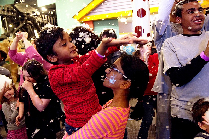 Children catch snowflakes in their hands at last year's Snow Day. (Contributed Photo)