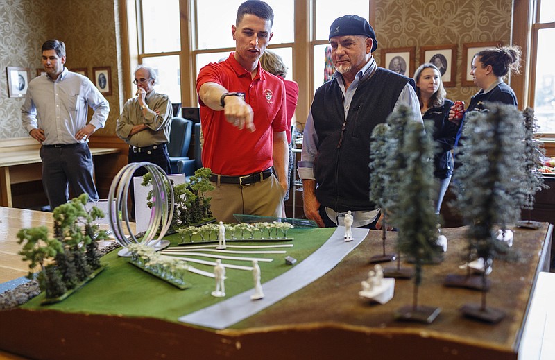 U.S.M.C. Capt. Patrick Sansbury, left, talks with Gordon Huether about his design concept for a "Fallen Five" memorial during a reception at City Hall on Wednesday, Nov. 15, 2017, in Chattanooga, Tenn. Three semifinal artists revealed their design concepts for a memorial to honor the five servicemen who were killed in the July 16, 2015 attacks on military facilities in Chattanooga.