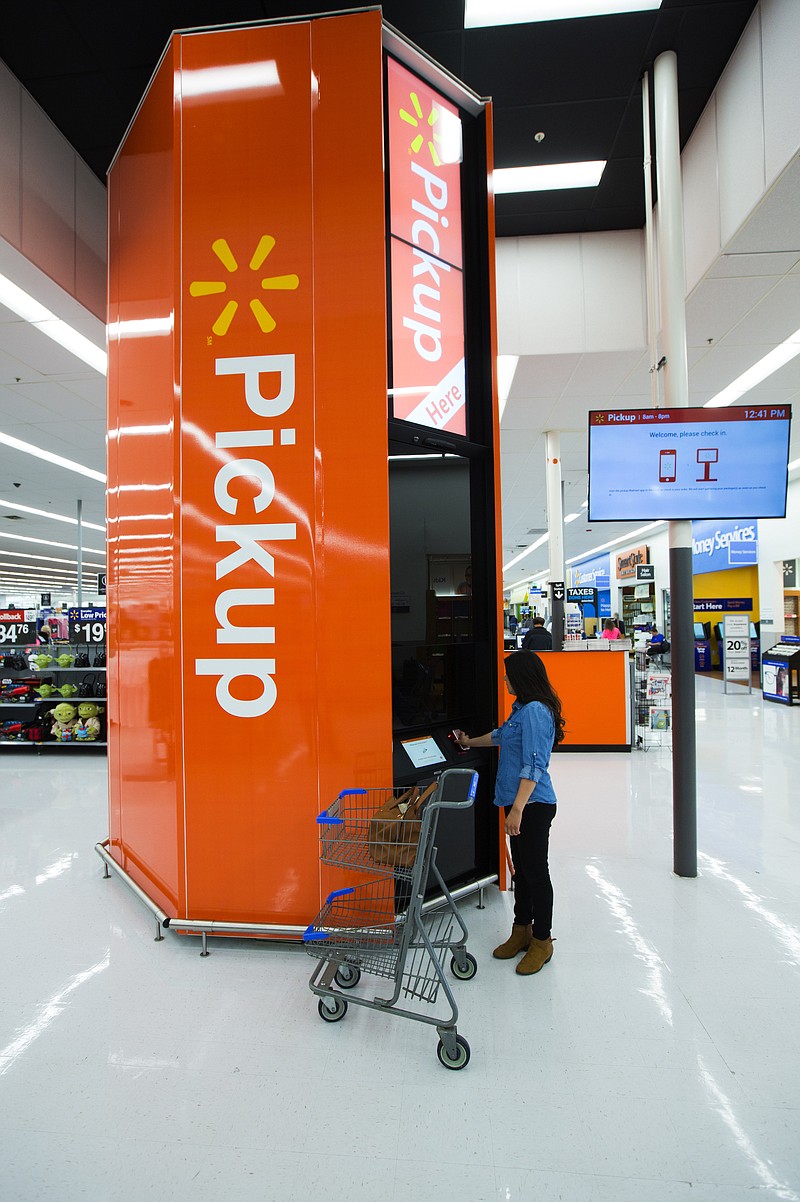 A shopper gets her order at a Walmart pickup tower. The towers are designed to fulfill a customer's online order faster, according to the retailer.