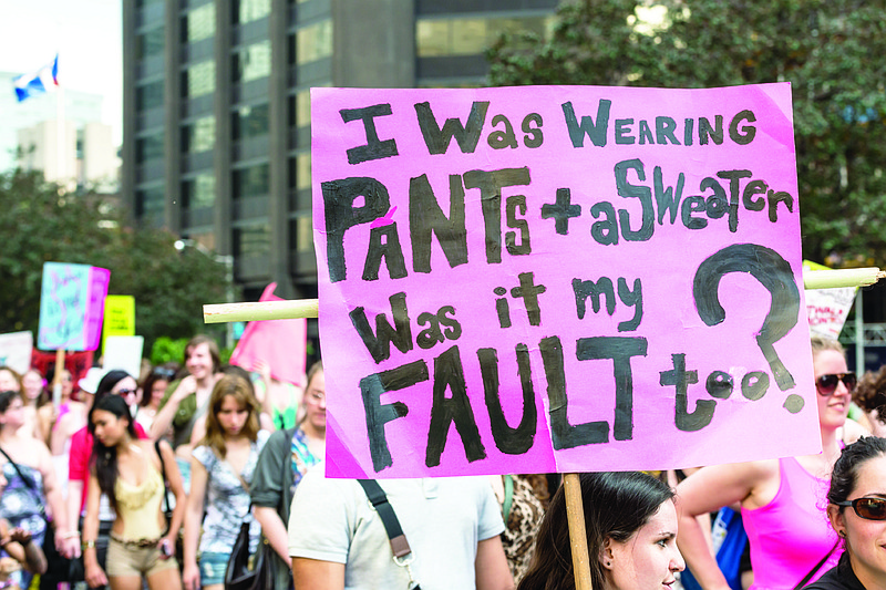 A protester holds a sign reading, "I was wearing pants + a sweater, was it my fault too" during a national protest about sexual assault and victims' rights, among other related issues. (Contribtued photo)