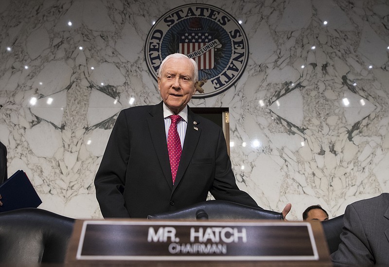 In this Nov. 13, 2017, photo, Senate Finance Committee Chairman Orrin Hatch, R-Utah, arrives as the tax-writing panel begins work on overhauling the nation's tax code, on Capitol Hill in Washington. Millions would forgo coverage if Congress repeals the unpopular requirement that Americans get health insurance, gambling with their own wellbeing and boosting premiums for others. Just as important, the drive by GOP senators to undo "Obamacare's" coverage requirement fits in with Trump administration efforts to write regulations allowing for plans with limited benefits and lower premiums. (AP Photo/J. Scott Applewhite, File)