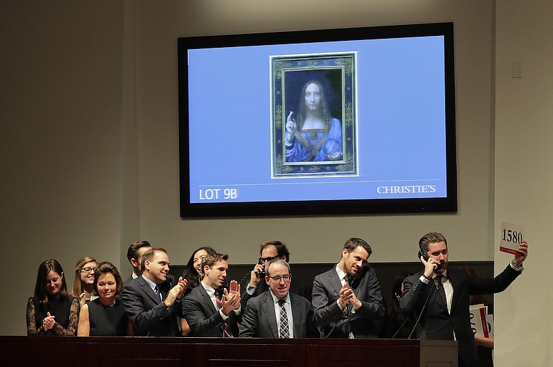 Bidding representatives react after Leonardo da Vinci's "Salvator Mundi" sold for $450 million at Christie's, Wednesday, Nov. 15, 2017, in New York. (AP Photo/Julie Jacobson)