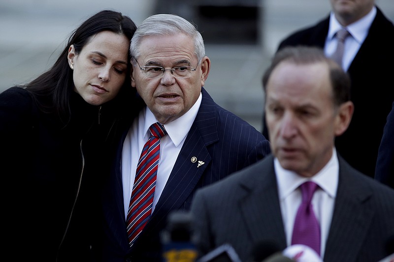 U.S. Sen. Bob Menendez, center, stands with his daughter, Alicia, as his lawyer Abbe Lowell, right, speaks to reporters outside Martin Luther King Jr. Federal Courthouse after U.S. District Judge William H. Walls declared a mistrial in Menendez' federal corruption trial, Thursday, Nov. 16, 2017, in Newark, N.J. (AP Photo/Julio Cortez)