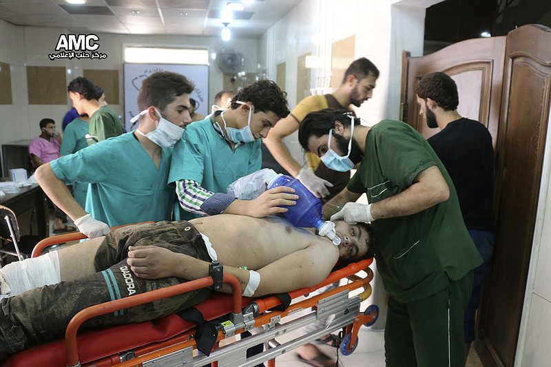 In this Sept. 6, 2016, file photo, provided by the Syrian anti-government activist group Aleppo Media Center (AMC), shows medical staff treating a man suffering from breathing difficulties inside a hospital in Aleppo, Syria after a chemical attack. Rival U.S. and Russian resolutions to extend the mandate of experts trying to determine who was responsible for chemical attacks in Syria were defeated Thursday, Nov. 16, 2017, at a United Nations Security Council meeting. (Aleppo Media Center via AP, File)