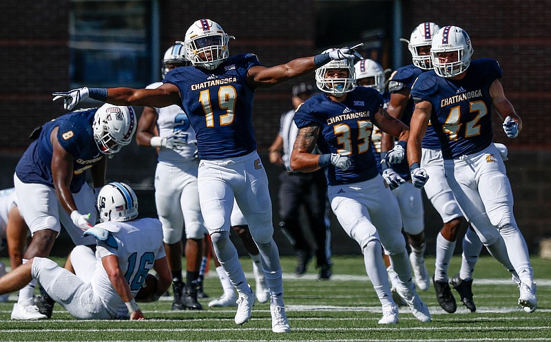 UTC's Tae Davis (19), Michael Bean (35) and Hawk Schrider (42) celebrate a defensive stop during a game against The Citadel on Oct. 21 at Finley Stadium. The Mocs close the season today by hosting ETSU, and Davis is among the seniors who will be honored before the game.