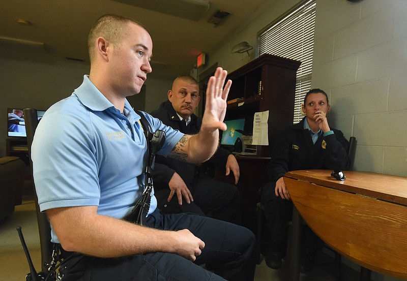 Paramedic Douglas Evans, left, talks his experience responding to the Woodmore bus crash scene one year ago.  Lieutenant Tony Sylvester, left, and Paramedic Stacie Liles listen to the account recently at Medic 11 station.