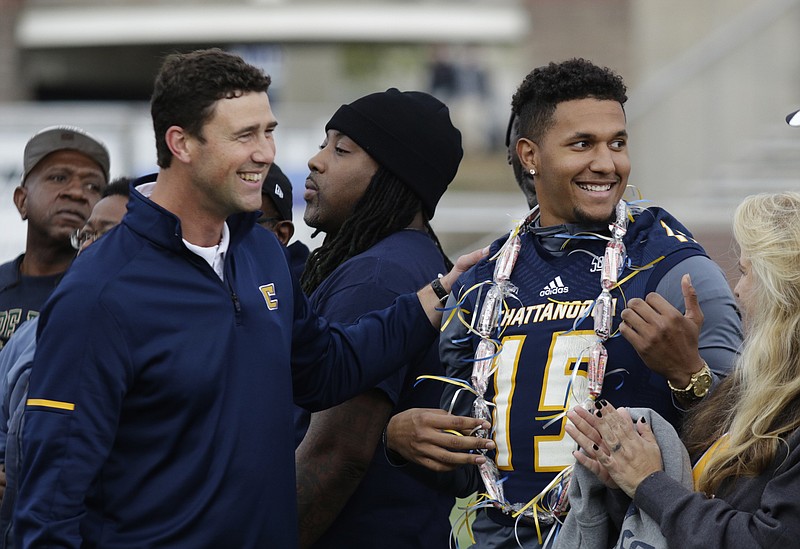 UTC head football coach Tom Arth, left, greets Alejandro Bennifield as graduating seniors are honored before the Mocs' final home football game of the season against the ETSU Buccaneers at Finely Stadium on Saturday, Nov. 18, 2017, in Chattanooga, Tenn.
