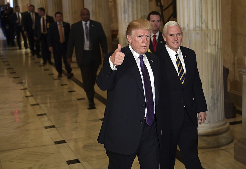 President Donald Trump gives a thumbs up as he walks with Vice President Mike Pence as he departs Capitol Hill in Washington, Thursday, Nov. 16, 2017.