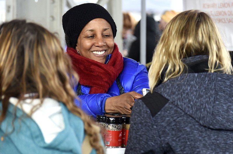 Kellie Anisa Ali, of Anisa's Secrets, is all bundled up for the weather as she waits on waits on customers at the Chattanooga Market on Sunday, Nov. 19, 2017.